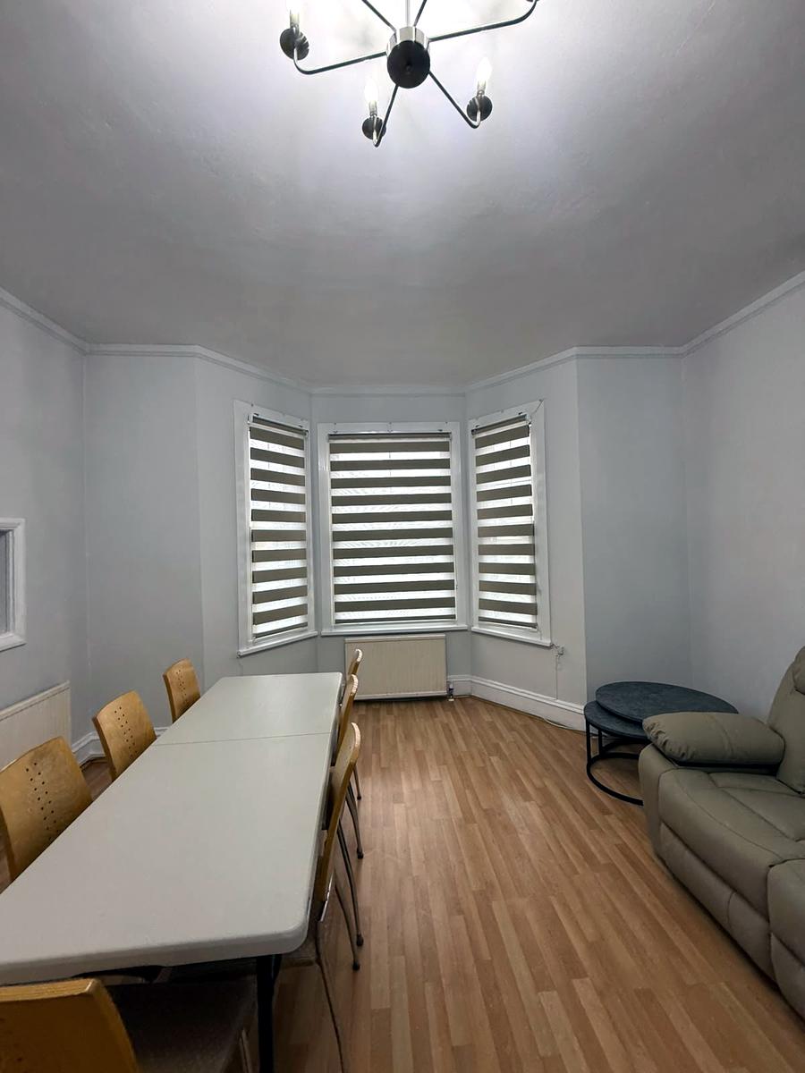Day and night blinds across a bay window in a living and dining room