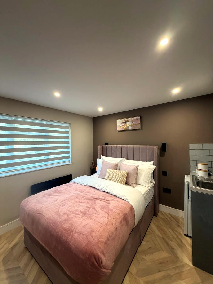 Styled studio bedroom with a grey day and night blind over the window
