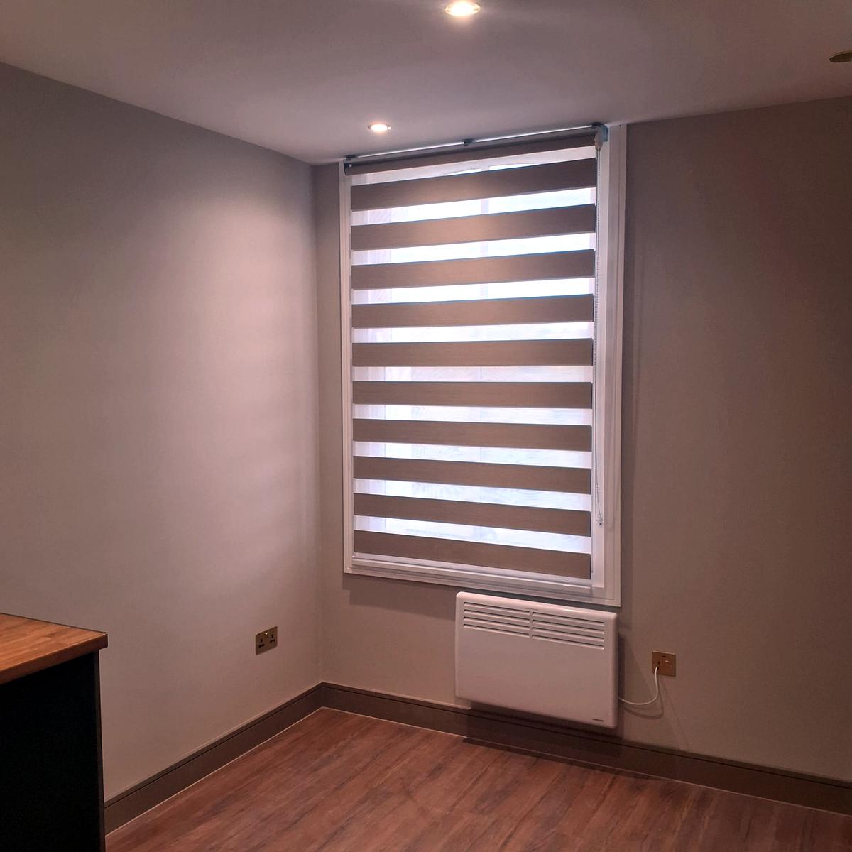 Taupe day and night blind on a tall window in a kitchen-diner