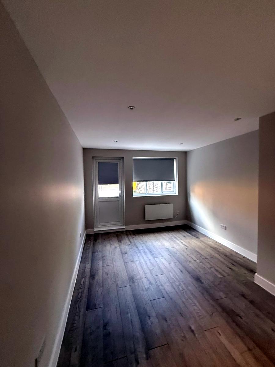 Roller blinds on a window and a back door in a long ground-floor room
