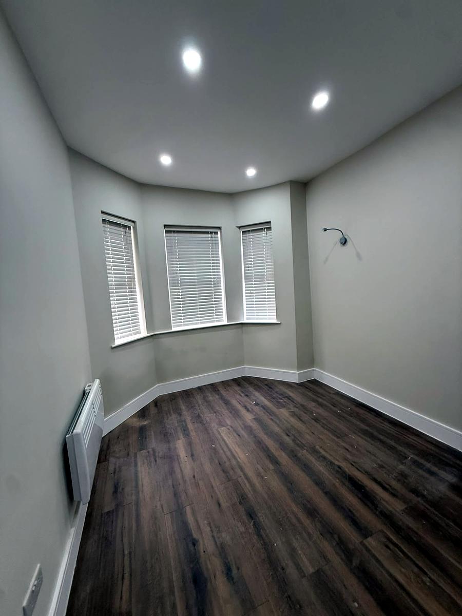 White venetians across a three-pane bay window in a bedroom